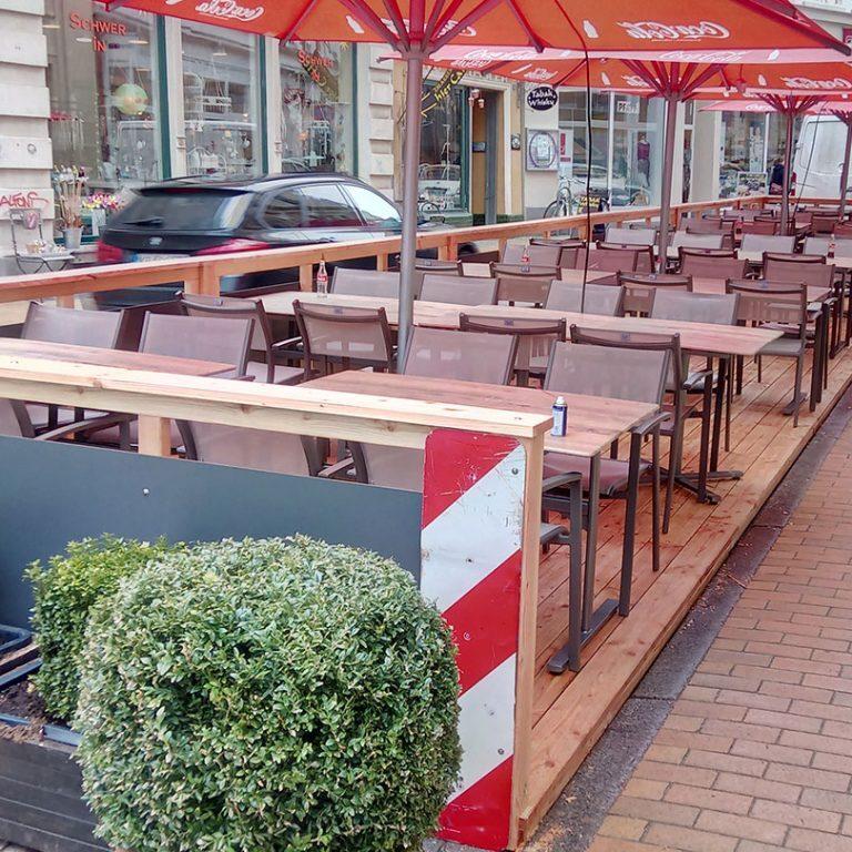 Terrasse für Gastronomie mit Holztischen und Bänken