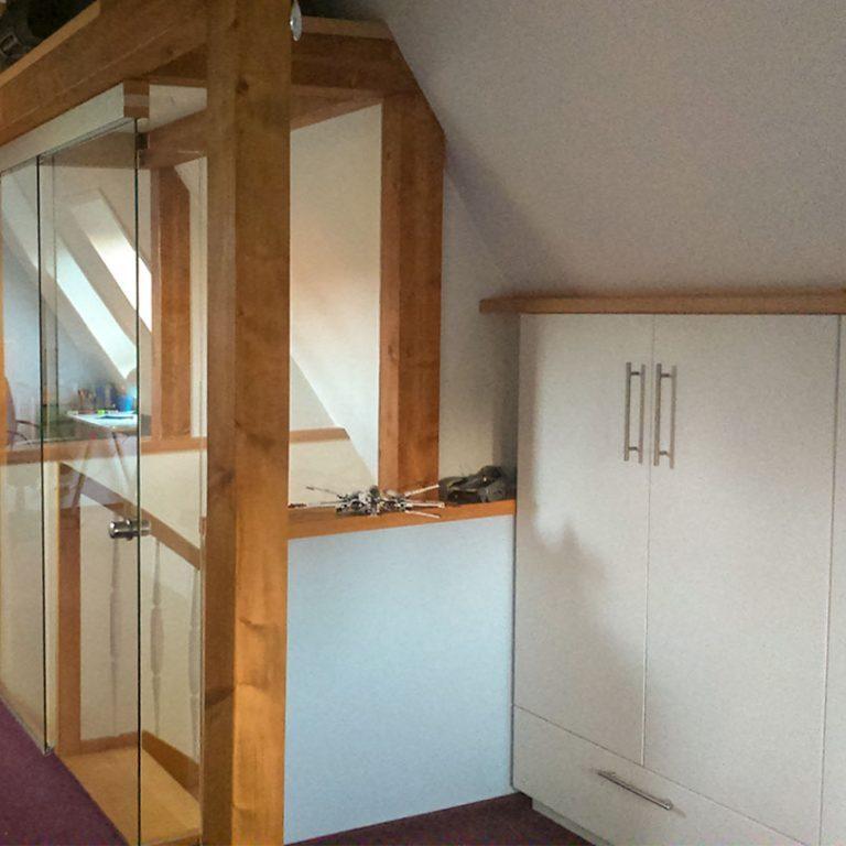 Dachausbau nach Maß Dachausbau nach Maß bestehend aus Schränken mit weißen Fronten und Holzelementen