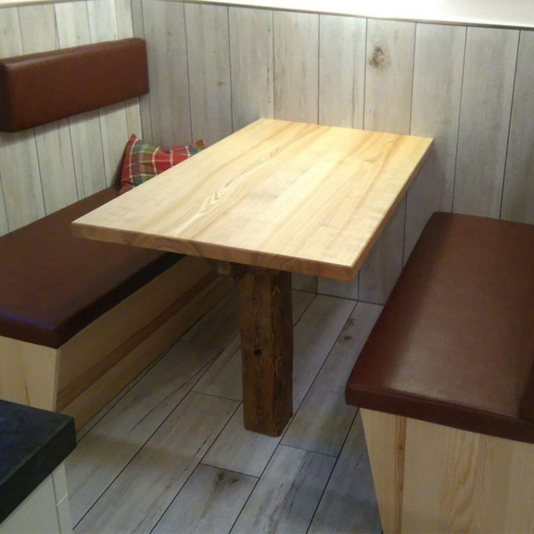 Maßgefertigte Küchenbank mit Holztisch und Polsterung Rustikale Küchenbank nach Maß mit gepolsterten Sitzflächen und Lehnen, kombiniert mit einem robusten Holztisch in einer gemütlichen Sitzecke.