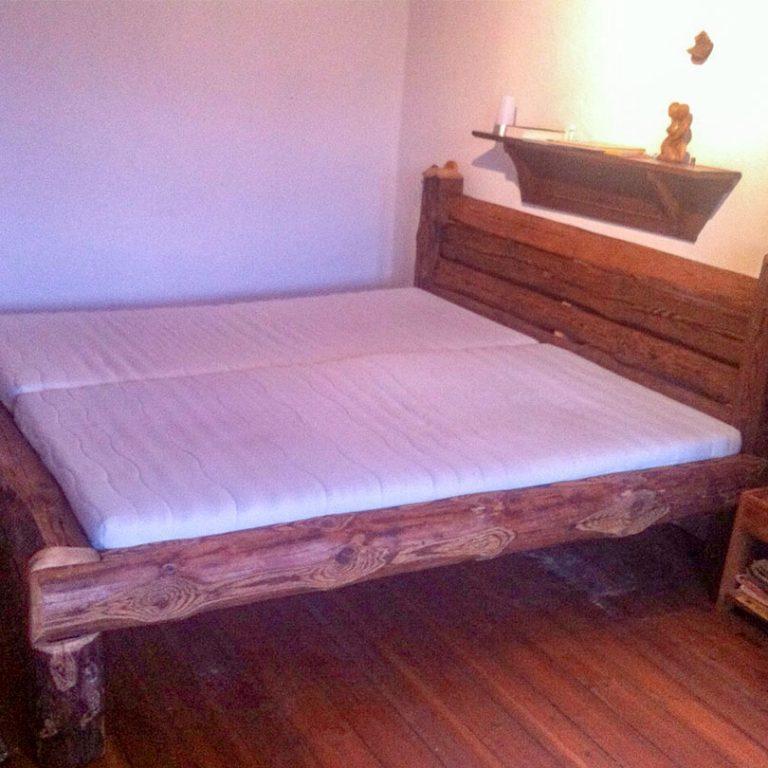 Individuelle Bett nach Maß vom Tischler Bettgestell aus dunklem Holz mit zwei Matratzen im Schlafzimmer