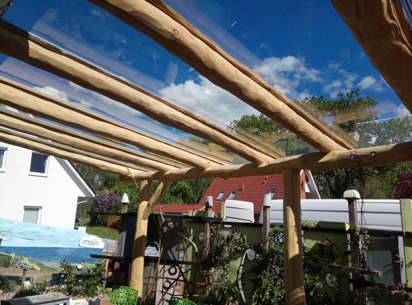 Terrassenüberdachung mit Holzbalken und Glaselementen