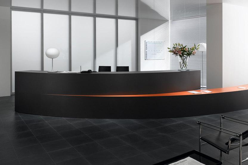 Hotelrezeption mit schwarzem Einrichtungsstil Hotelrezeption mit schwarz lackierter Empfangstheke und orangenem Kontrast