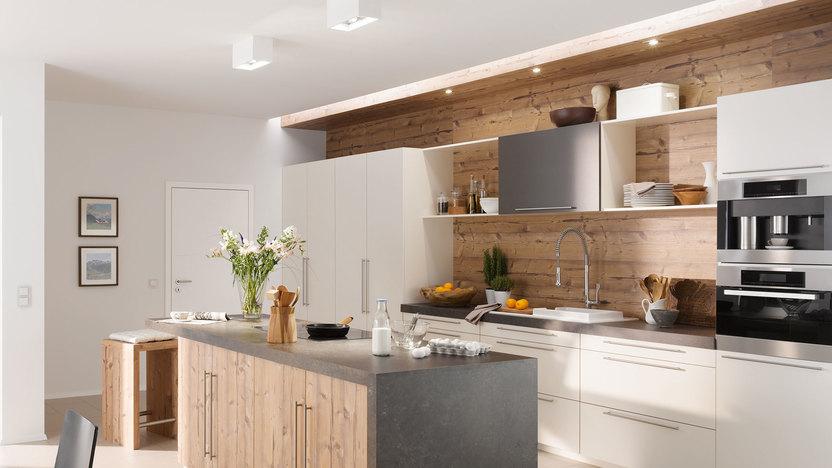 Impressionen einer Küche mit Esszimmer mit hellen Holzmöbeln und dunklen und weißen Fronten im Kontrast