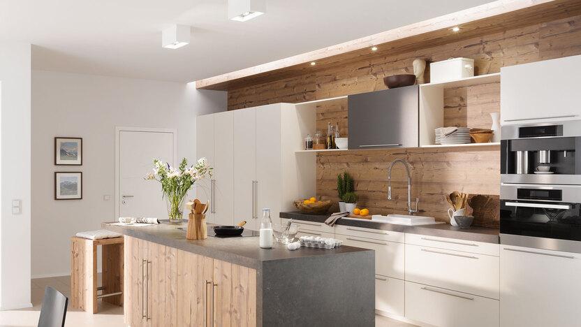 Impressionen einer Küche mit Esszimmer mit hellen Holzmöbeln und dunklen und weißen Fronten im Kontrast