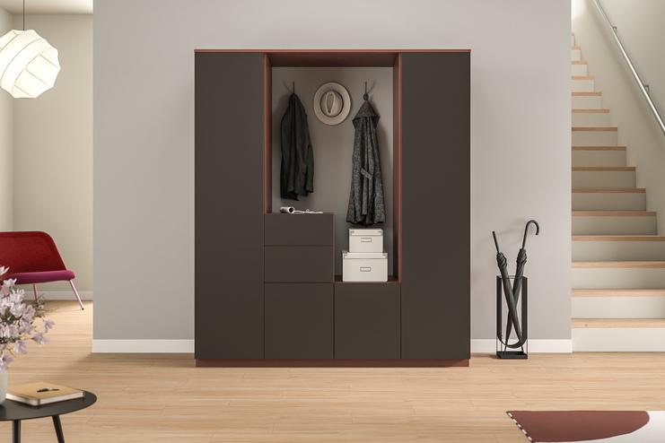 Ein dunkler, maßgeschneiderter Schrank mit integrierter Garderobe und Schubladen, praktisch für die Aufbewahrung von Jacken und Accessoires im Eingangsbereich.